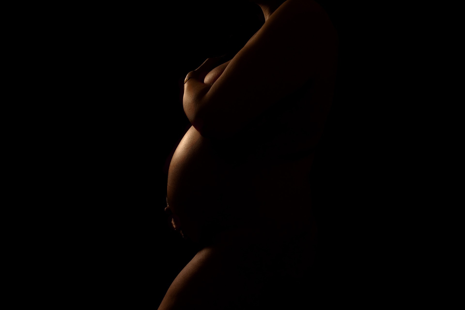 Artistieke zwanger fotoshoot met weinig licht